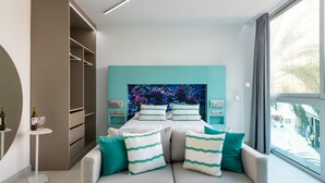 A modern bedroom with a bed, teal accent walls, a large window, and a view of the street. - Edison Building 202 By Canariasgetaway (Las Palmas de Gran Canaria)