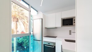 A modern kitchen with white cabinets, a built-in microwave, and a stainless steel refrigerator. - Edison Building 202 By Canariasgetaway (Las Palmas de Gran Canaria)