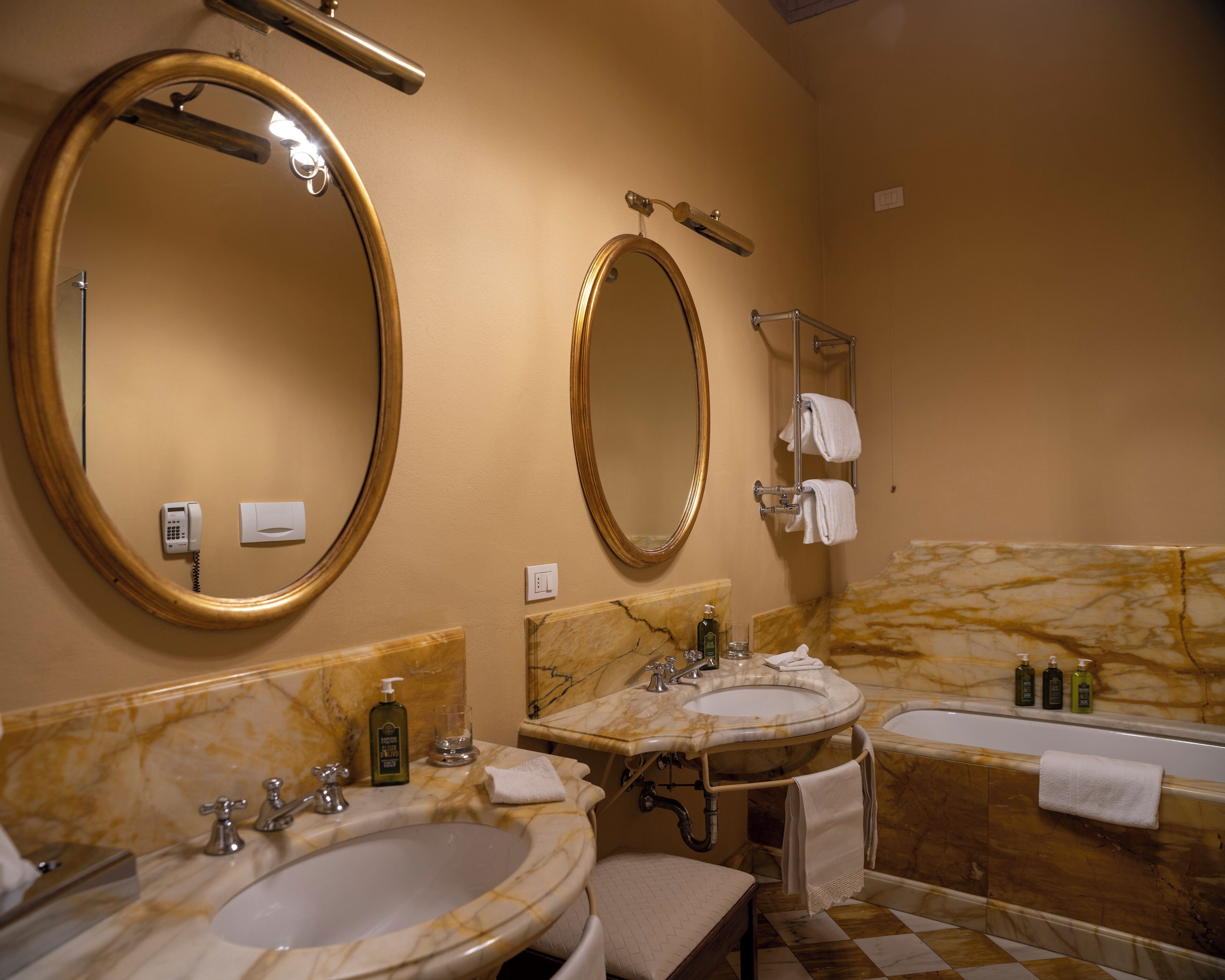 A bathroom with two sinks, a bathtub, and two large mirrors.