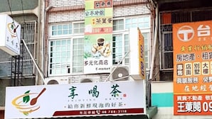 A storefront with multiple signs advertising various products and services, including tea and snacks. - Duo Yuan Hua BB (Chaozhou)