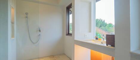 A modern bathroom with a shower, a sink, and a window providing a view of the outdoors.