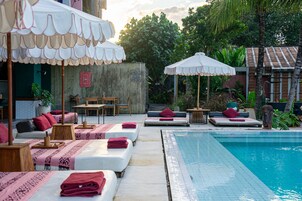 Una piscina al aire libre, sillones reclinables de piscina