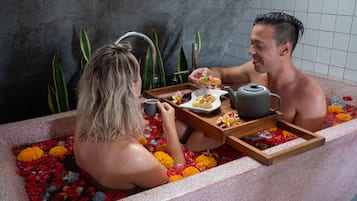 Relax in a serene space with a bathtub, teapot, and refreshments.