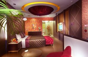 Una habitación de hotel moderna con una cama, un escritorio pequeño, una silla y una mesa redonda.