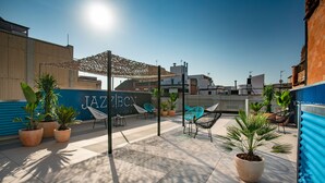 An outdoor patio area with potted plants, chairs, and a blue wall with the text "JAZZ CLUB". - Cool Jazz 24 - Habitat Apartments (Barcelona)