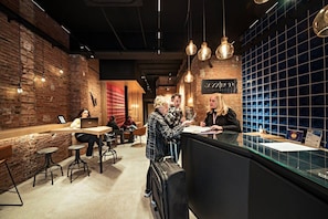 A cafe with brick walls, hanging pendant lights, and a counter with a menu. - Cool Jazz 24 - Habitat Apartments (Barcelona)