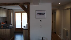 A modern kitchen with wooden cabinets and a built-in oven. There is a framed picture on the wall and a door leading to another room. - Chalet adjoining Les Contamines-Montjoie, sleeps 10 (Les Contamines-Montjoie)