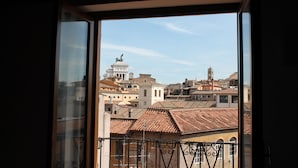 A view from a window overlooking a cityscape with buildings and a prominent white dome structure. - BB Il Re Alla Reginella Guest House (Rome)