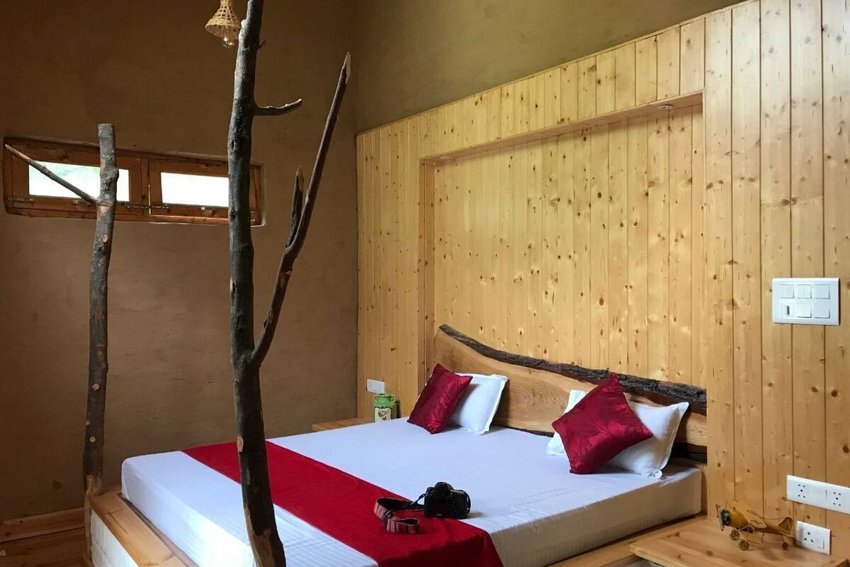 A wooden room with a bed, a window, and a wooden headboard.