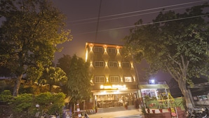 Un hotel con restaurante en la planta baja y numerosas ventanas en los pisos superiores.