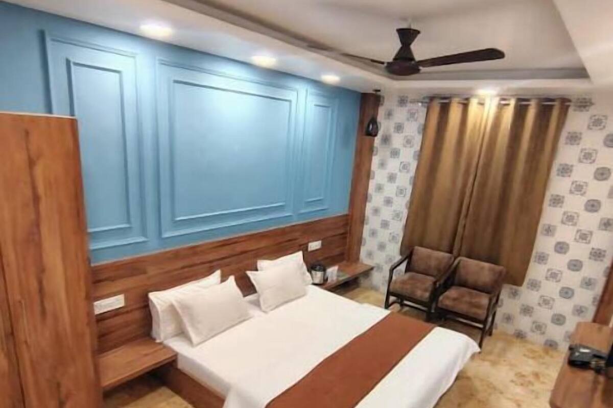 Ein Schlafzimmer mit Bett, Stuhl, Schreibtisch und Deckenventilator.