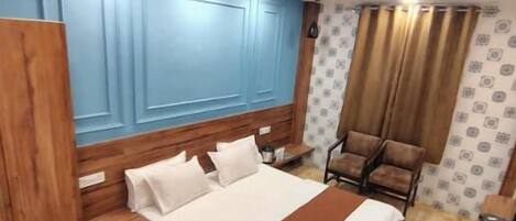 A bedroom with a bed, a chair, a desk, and a ceiling fan.
