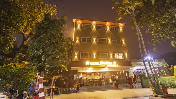 Un hotel con un letrero llamativo, varias ventanas y un balcón.