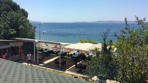 Un espacio al aire libre frente al mar con mesas y sillas.