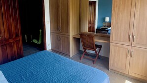 A bedroom with a bed, wooden wardrobe, and a desk with a chair. - Yelkovan Ada Evi (Marmara)