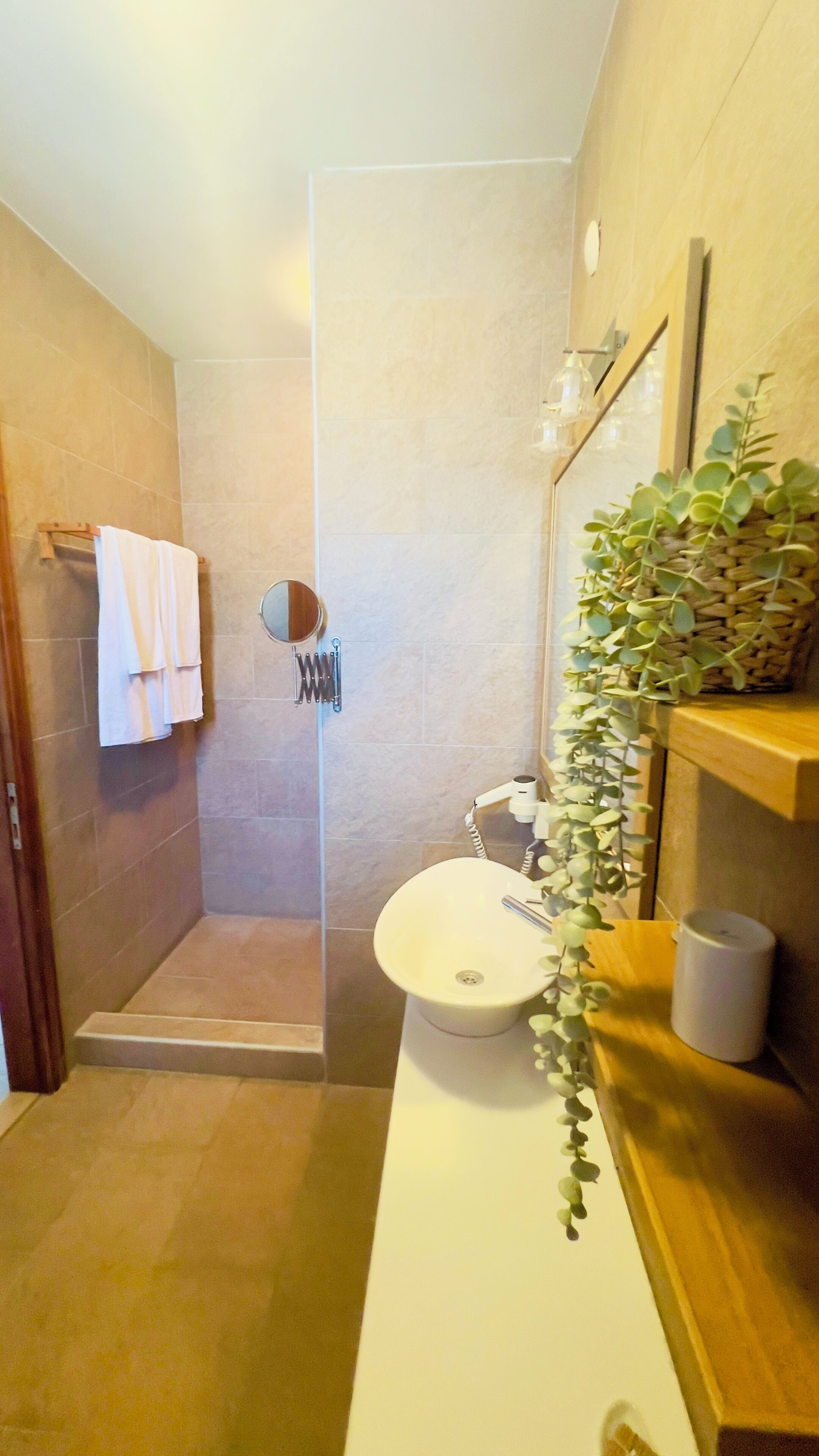 A modern bathroom with a shower, toilet, and sink.