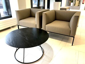 A modern interior with two beige armchairs and a black round table. - City Center Tower Apartment (Tampere)