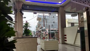 Un hall d’hôtel comprenant un comptoir d’accueil, un espace salon et un escalier menant aux étages supérieurs.