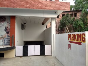 A parking area with a white wall and a sign indicating 'PARKING'.