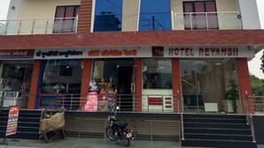 Un hôtel à plusieurs étages, reconnaissable à son grand panneau indiquant « HÔTEL REYANSH ».