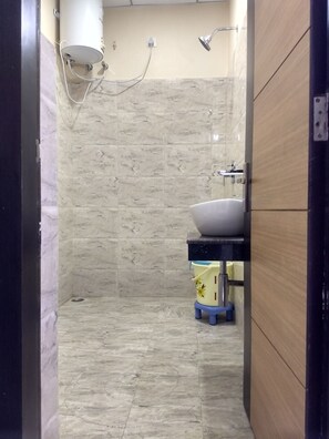 A bathroom with a shower, a sink, and a toilet.