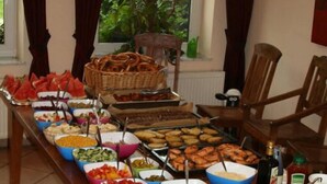 Una mesa de buffet con diferentes tipos de comida y una botella de aceite de oliva.