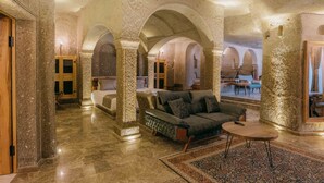 Un hallo amplio con un sofá moderno, una mesa de centro redonda y una alfombra estampada.