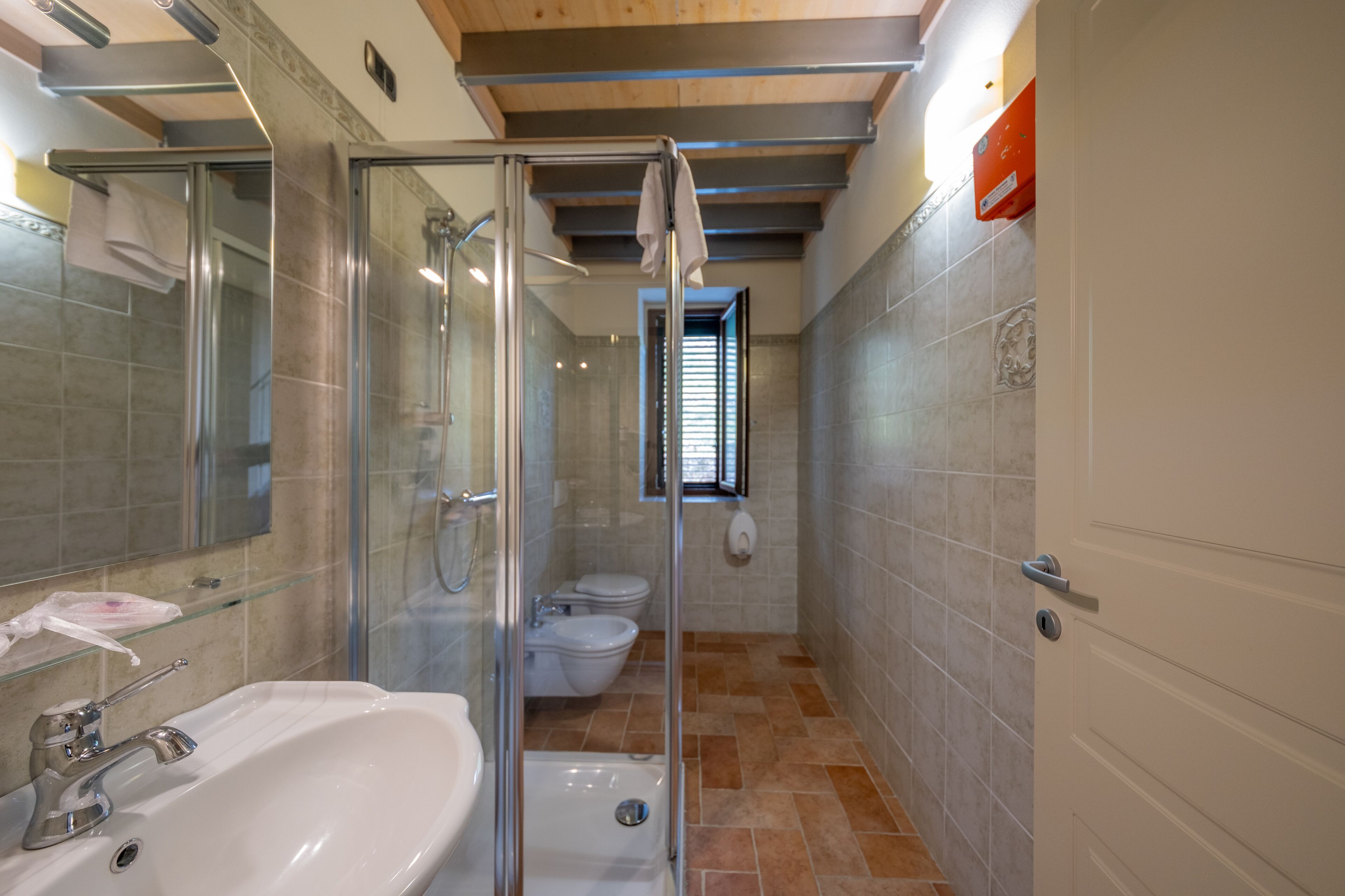 Une salle de bain moderne avec une douche à parois de verre, un lavabo et des toilettes.