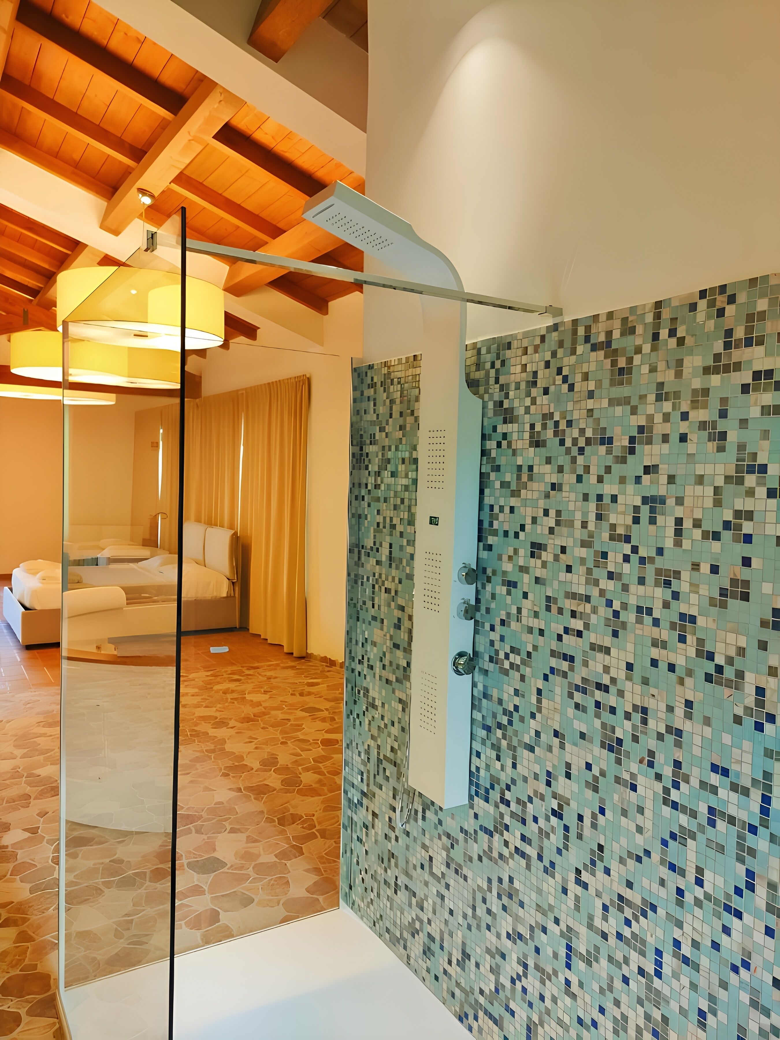 Ein modernes Badezimmer mit einer Wand aus Mosaikfliesen, einer Glasdusche und einem Steinboden.