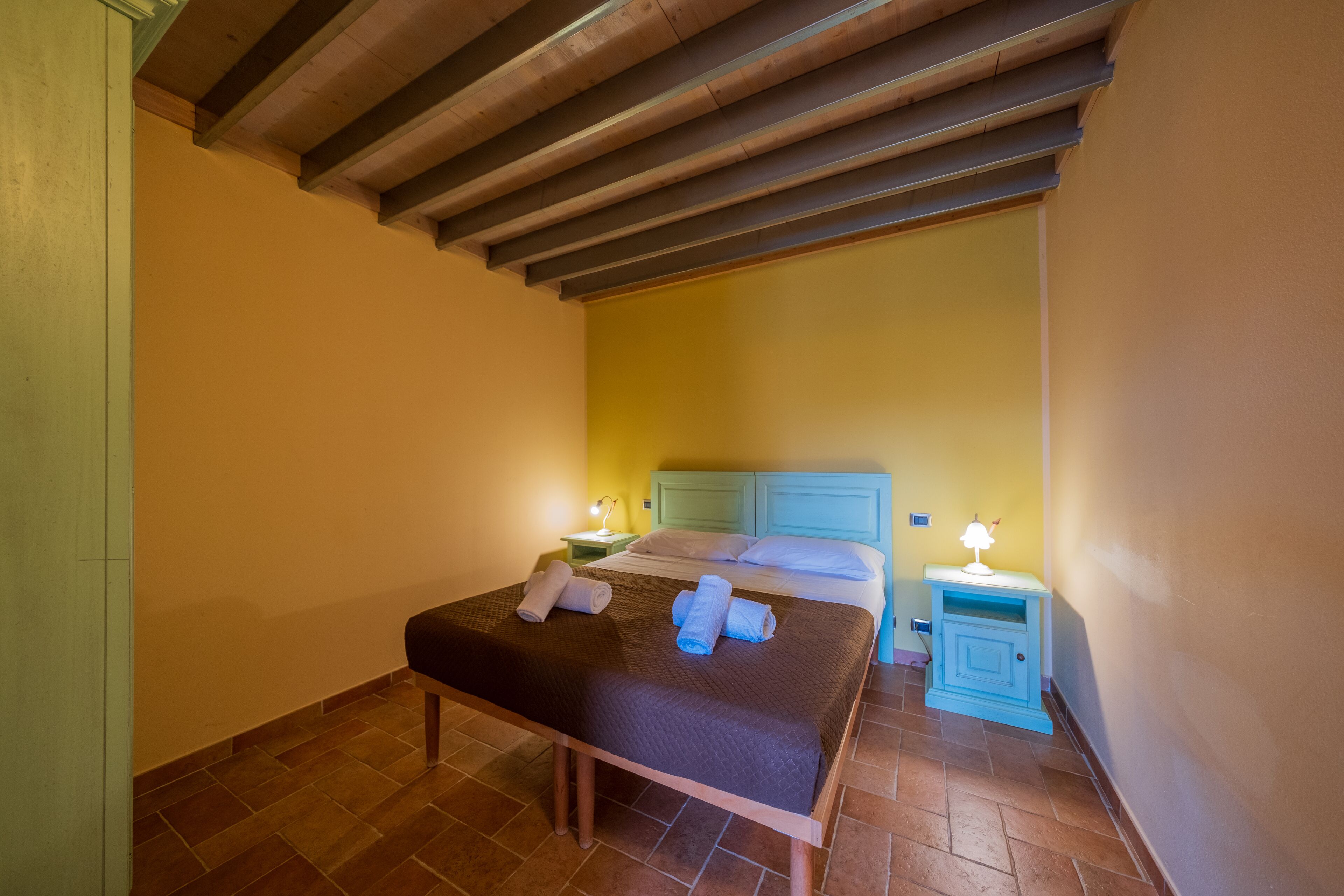A bedroom with a bed, bedside tables, and a bench.