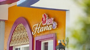 A building with a sign that reads "Hana" and decorative floral elements.