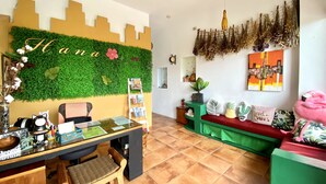 Una habitación acogedora con escritorio, una silla, sofá verde y una pared decorada con detalles verdes y una vista urbana.