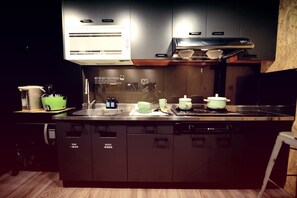 A modern kitchen with a built-in dishwasher, a sink, and a stove. - KID Hualien Hostel (Hualien City)