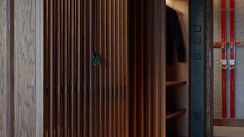 Een modern interieur met een houten paneelwand, een ski-rek en een houten vloer.