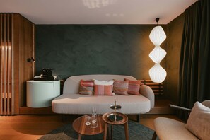 Suite superior, balcón, vistas a la montaña | Zona de estar | Una televisión, libros