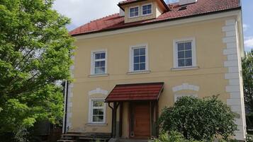 Traditional two-story building with a red-tiled roof and central entrance.