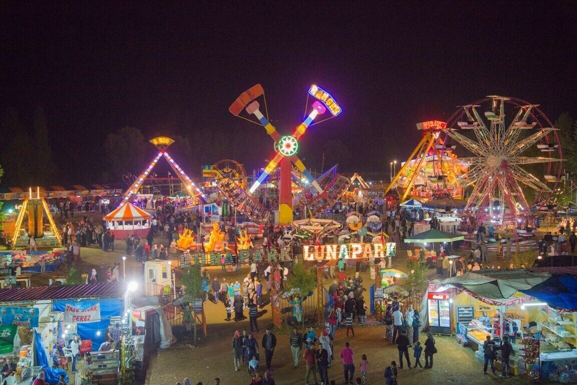 A nighttime amusement park with various rides and attractions.