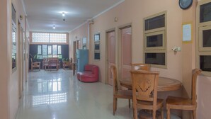 Un pasillo espacioso con comedor que incluye muebles de madera y una silla roja.