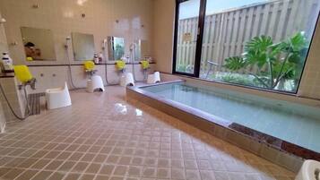 A bathroom with a large window, a glass-enclosed pool, and multiple sinks with yellow soap dispensers.