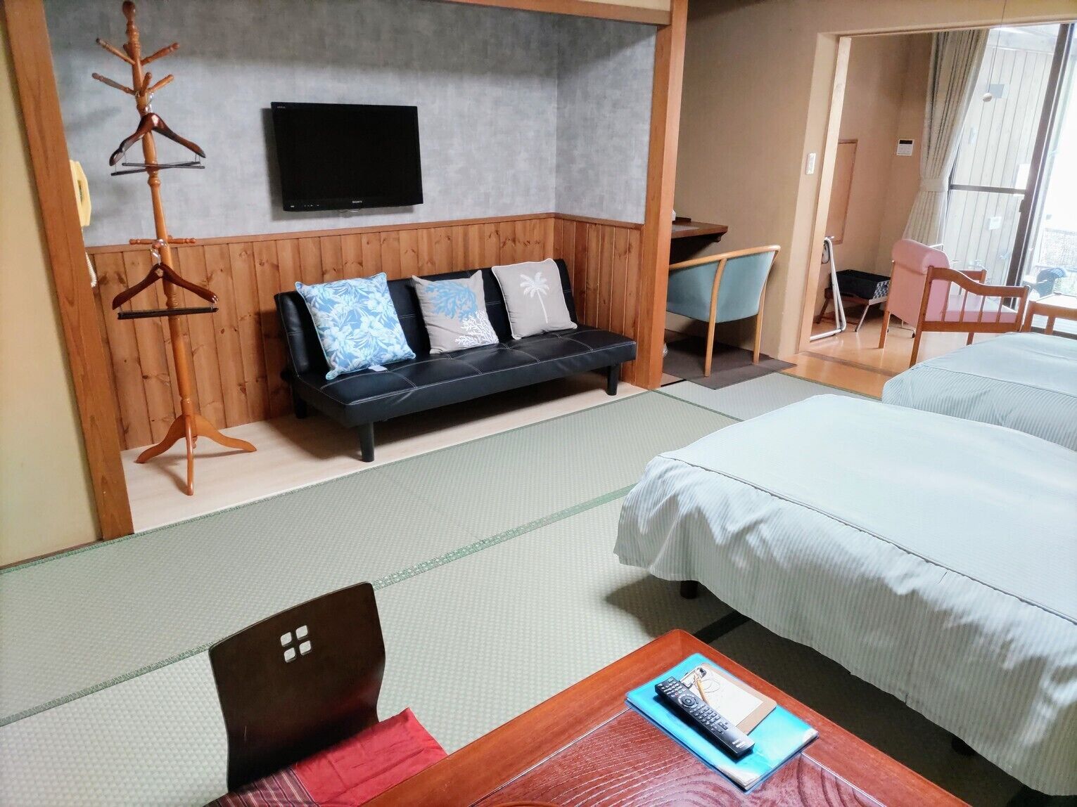 Una habitación de hotel con una cama, un sofá, un televisor, un escritorio y una silla.