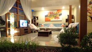 Una sala de estar moderna con televisor, sofá y mesa de centro.