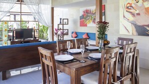 Comedor con una mesa de madera dispuesta para seis personas, rodeada de sillas.