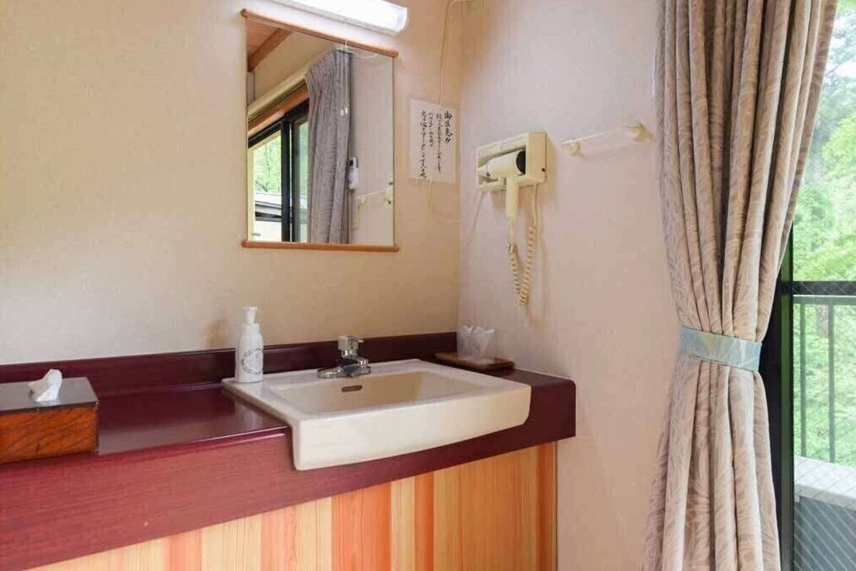 Un bagno con lavandino, specchio e telefono.