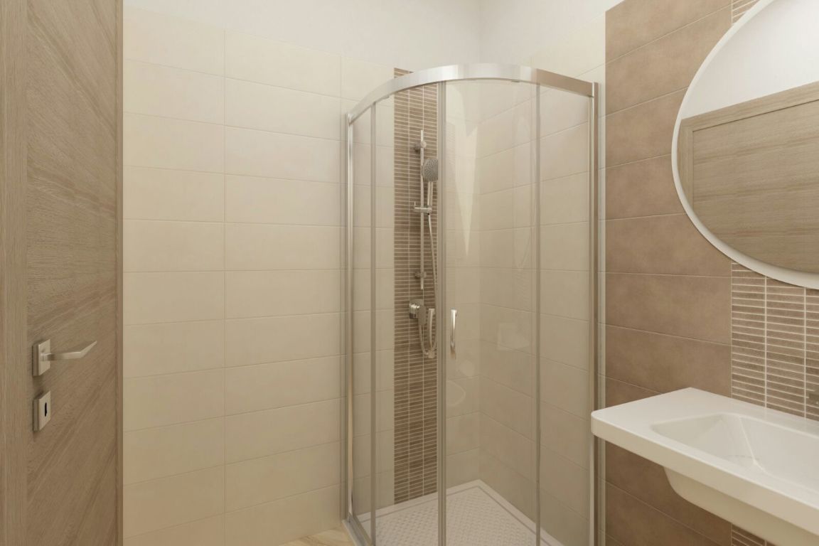 A modern bathroom with a glass-enclosed shower, a white sink, and a wooden vanity.
