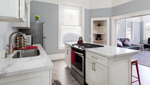A modern kitchen with white cabinetry, a stainless steel sink, and a built-in oven.
