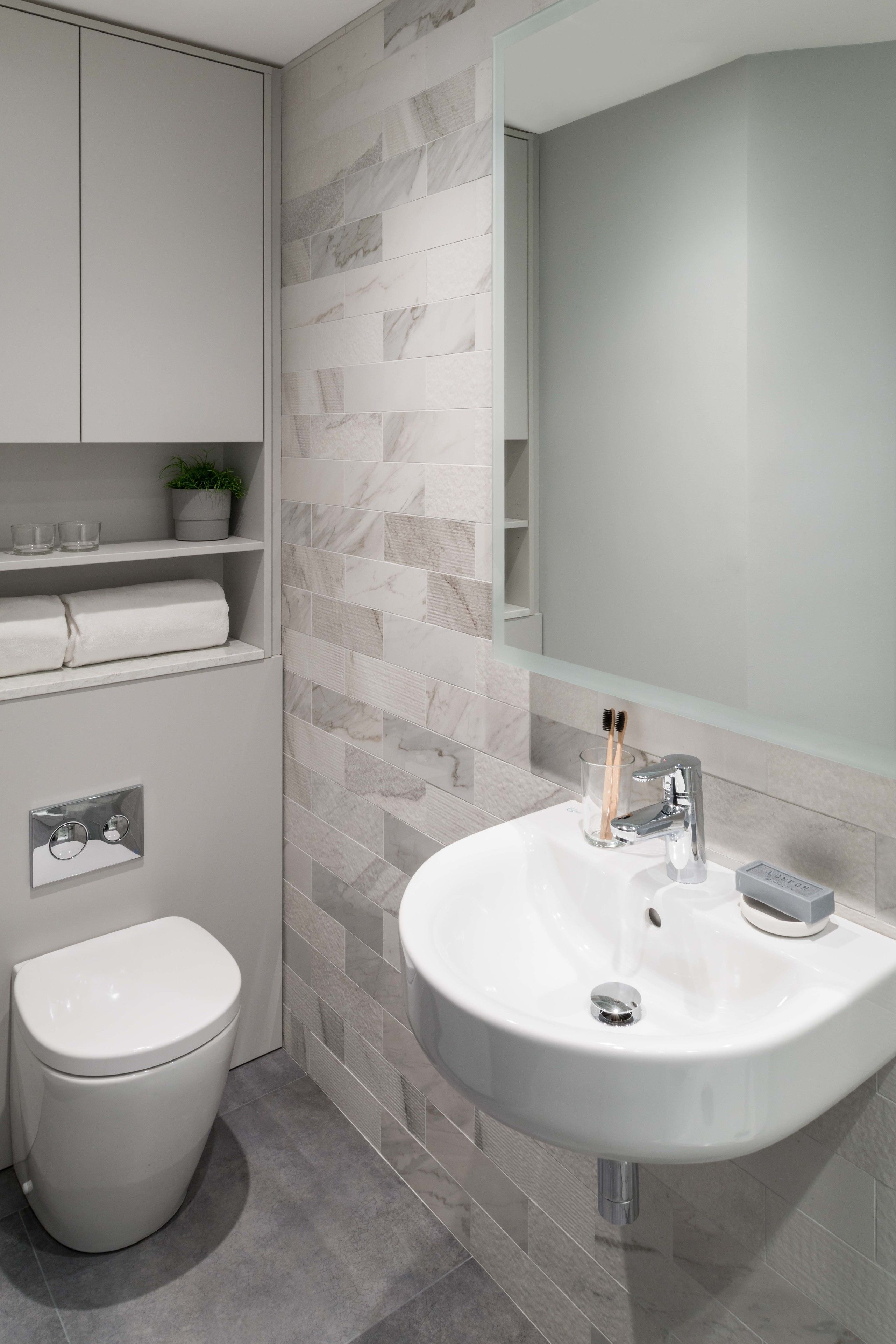 Ein modernes Badezimmer mit Waschbecken, Toilette und Spiegel.