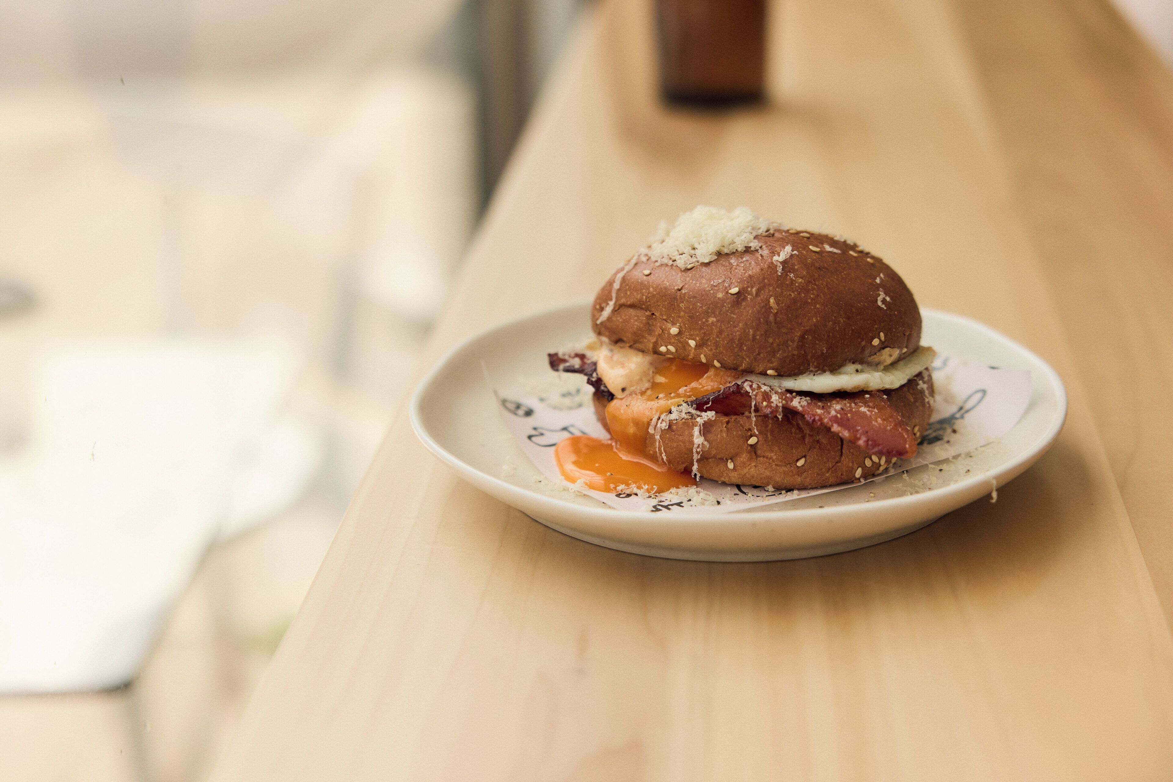 A sandwich on a plate on a wooden table.
