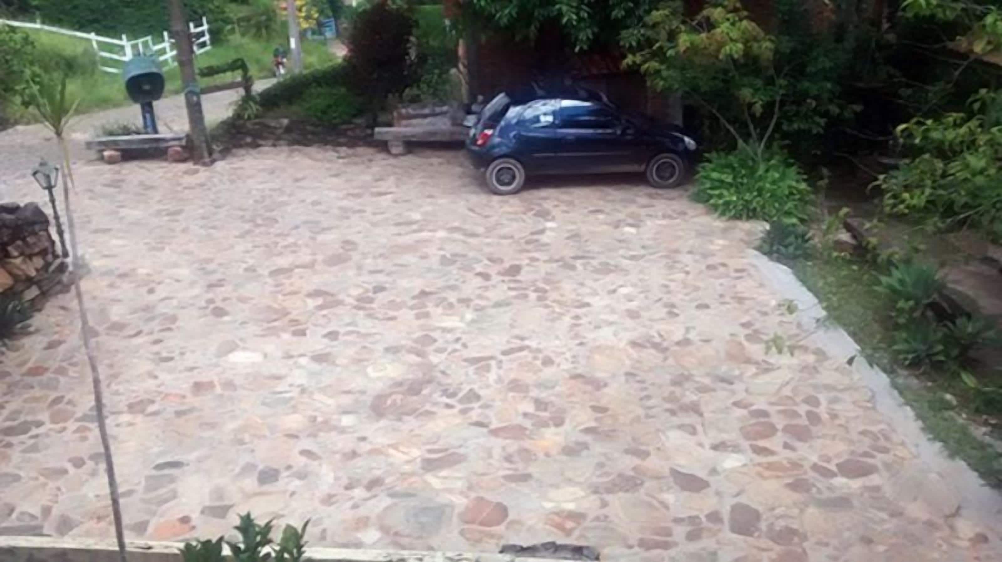 Une allée pavée avec une voiture garée sur le côté droit.