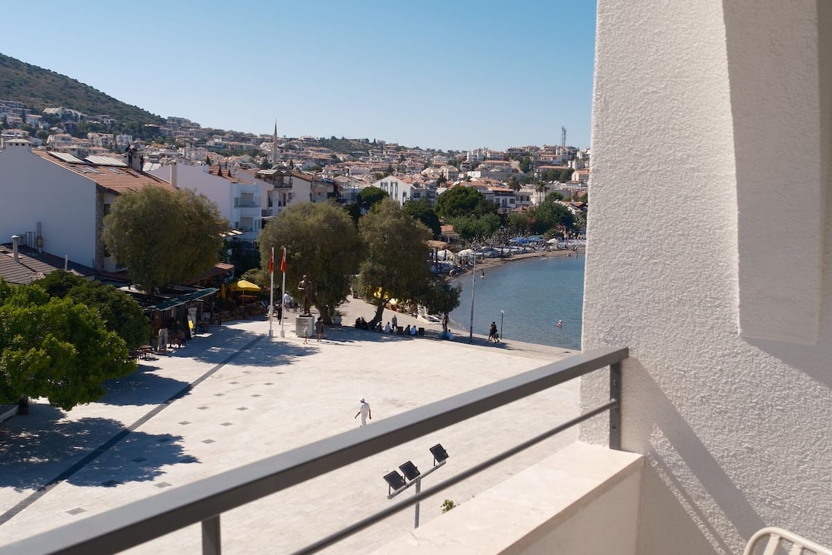 A balcony with a view of a town and a body of water.