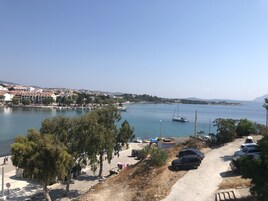 Un pueblo costero con un puerto deportivo, coches aparcados y un cielo despejado.